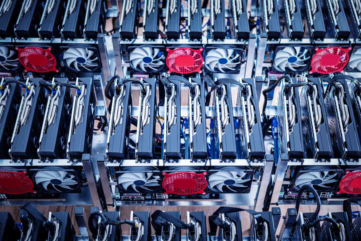 An overhead view of intense cryptocurrency mining equipment including parallel-linked drives and cooling fans.