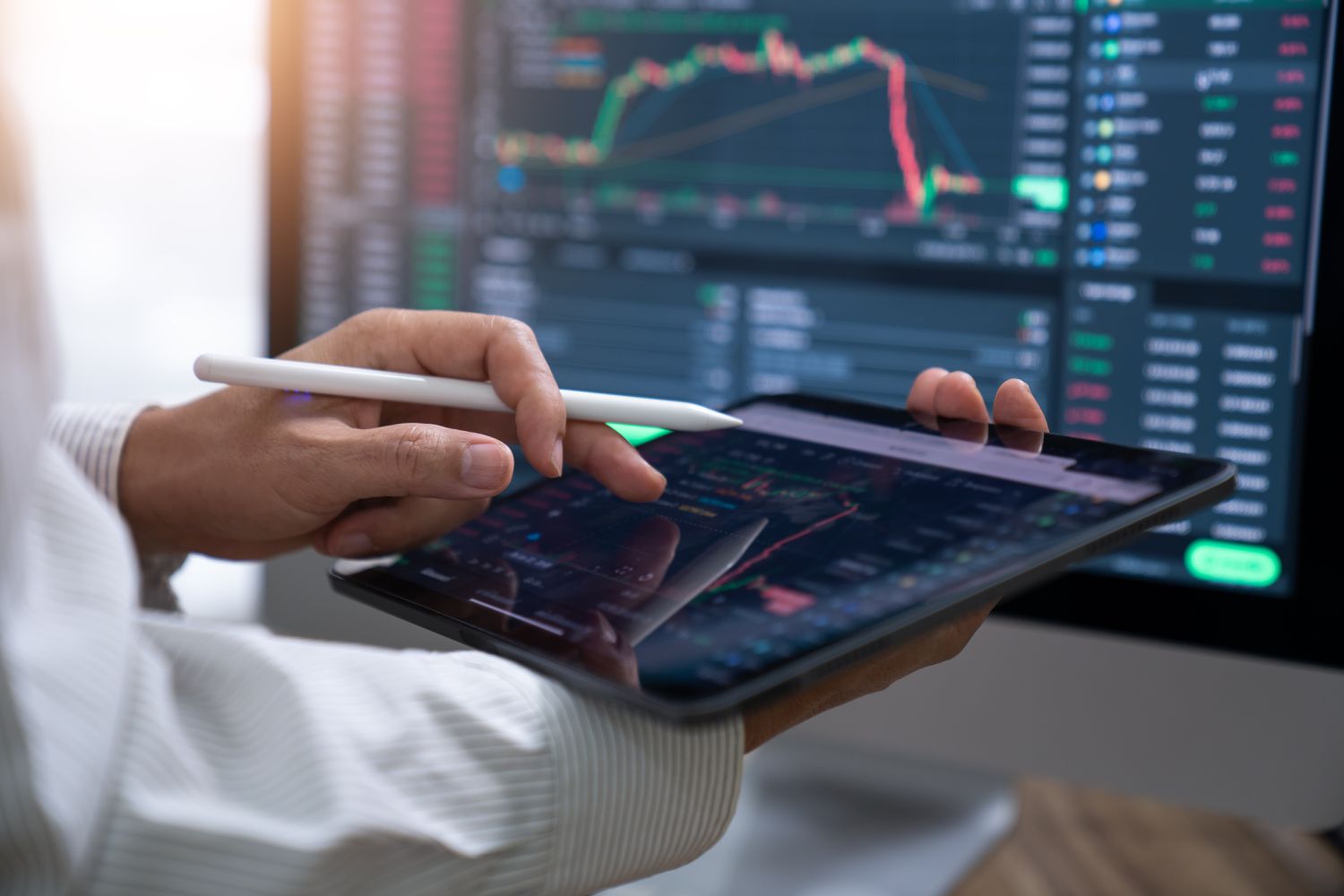 A person using a tablet and stylus to invest in stock