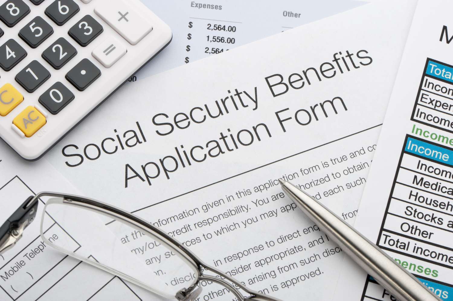 A social security application with calculator and pen.