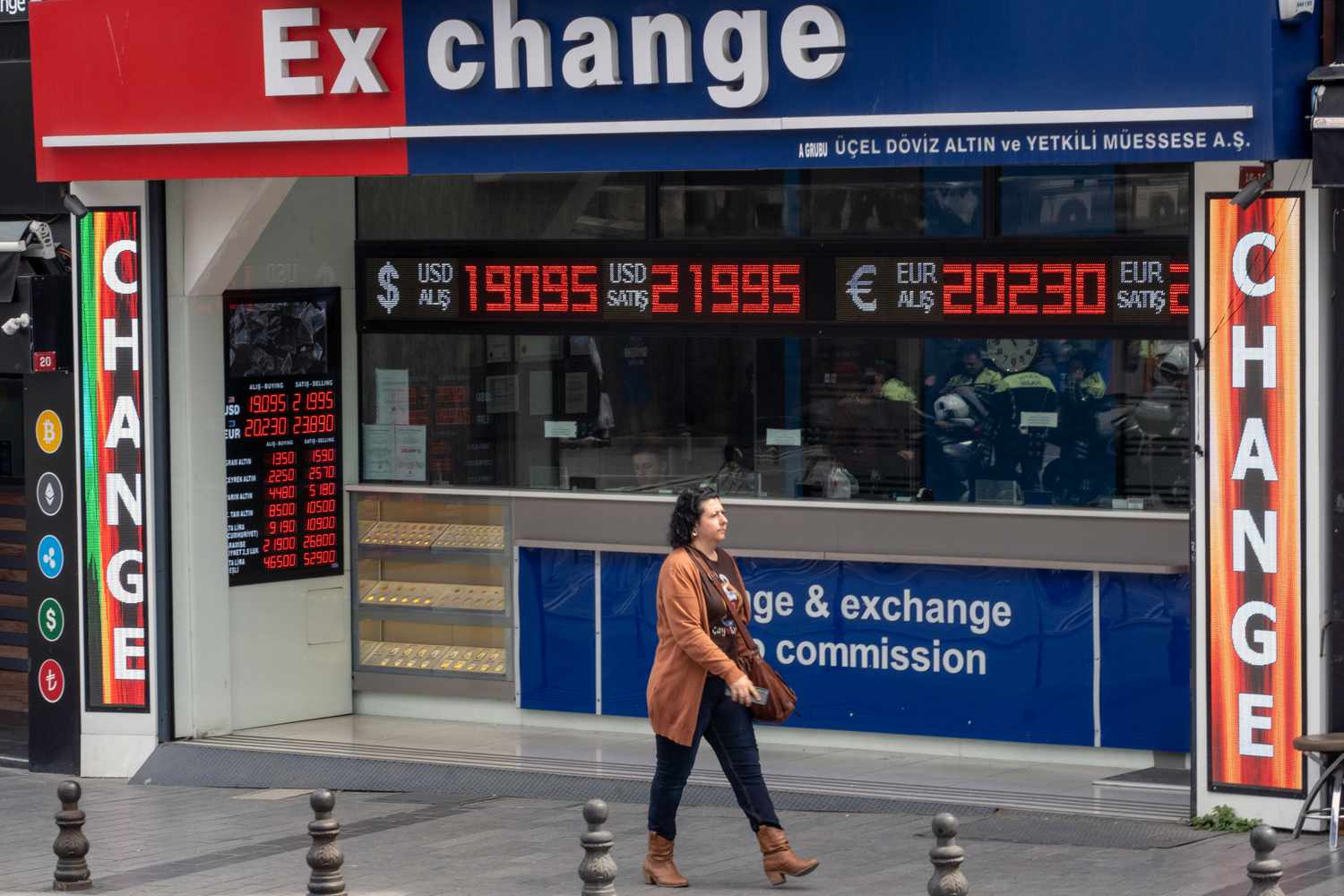 Woman walking on a street in front of a currecny exchange bureau
