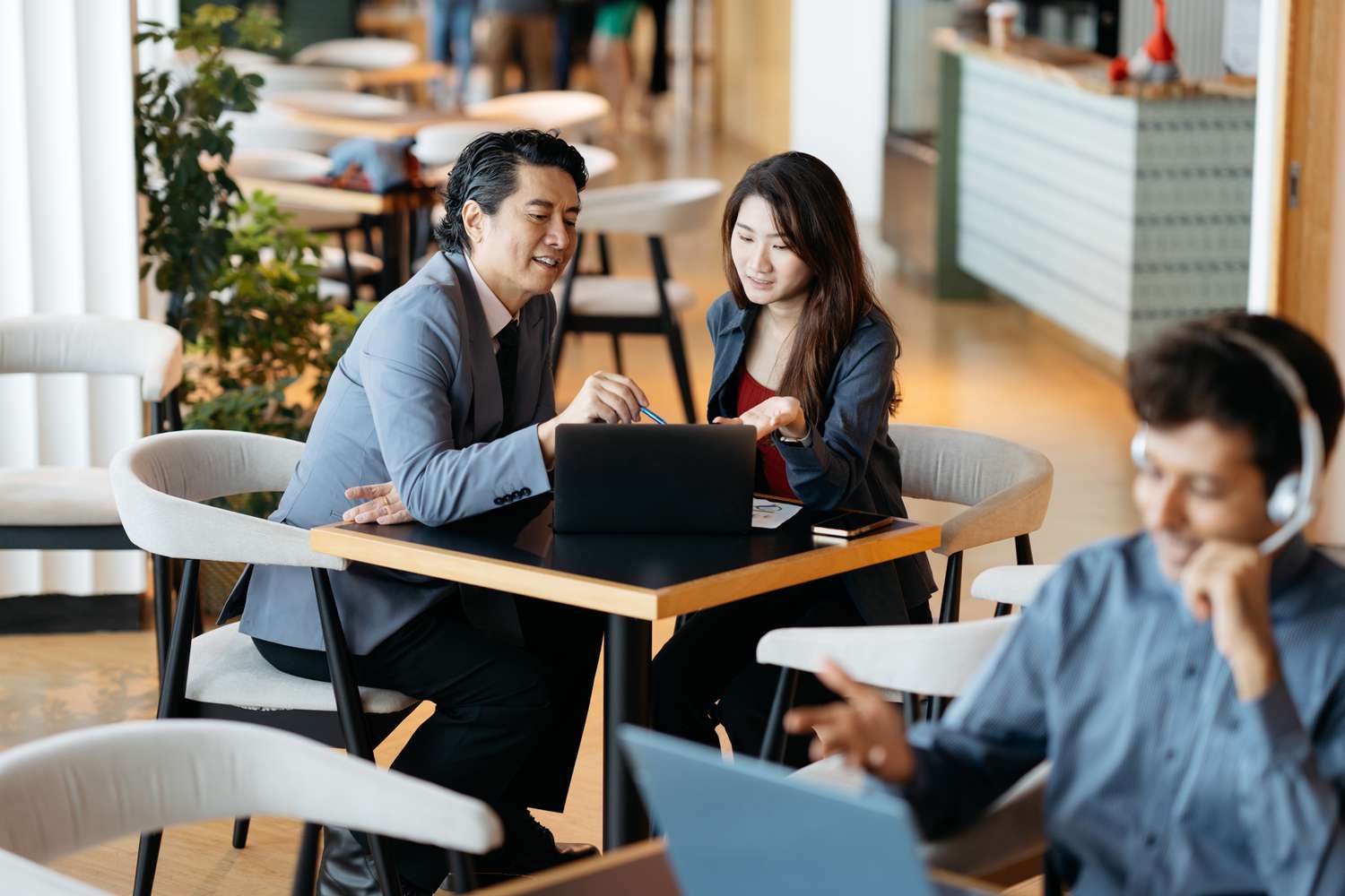 A retail investing couple use a laptop at a cafe during lunch to consider using a yield pickup strategy in their savings portfolio.