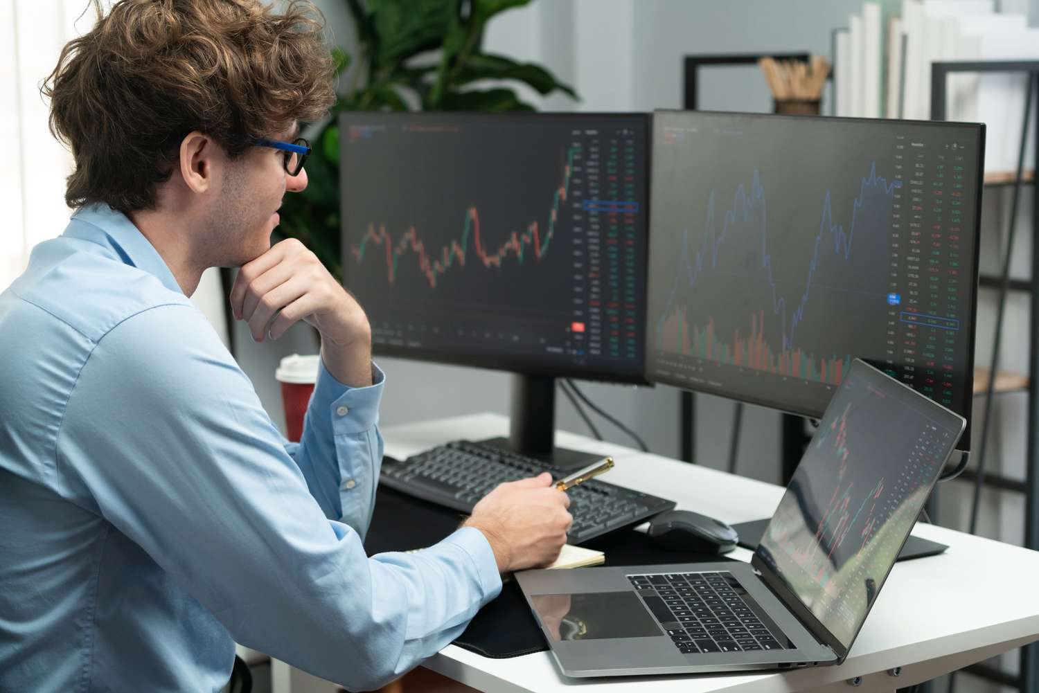 A trader looks at trading screens for signal lines convergence.