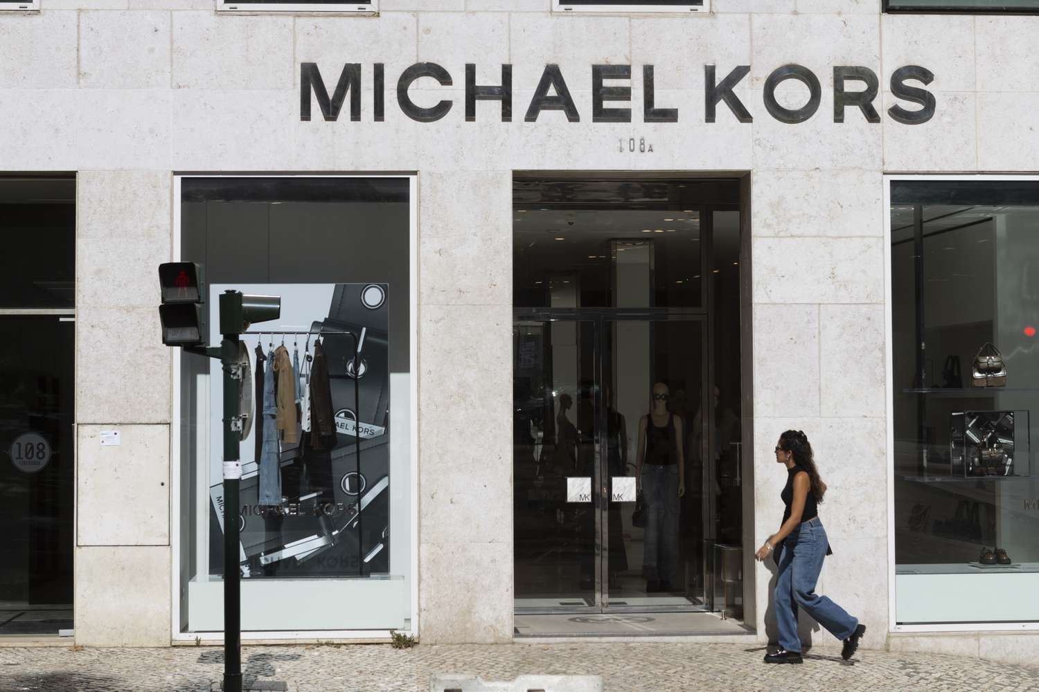 People walk by a Michael Kors store in Lisbon, Portugal.