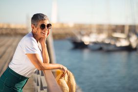woman looking out over a marina with sailboats