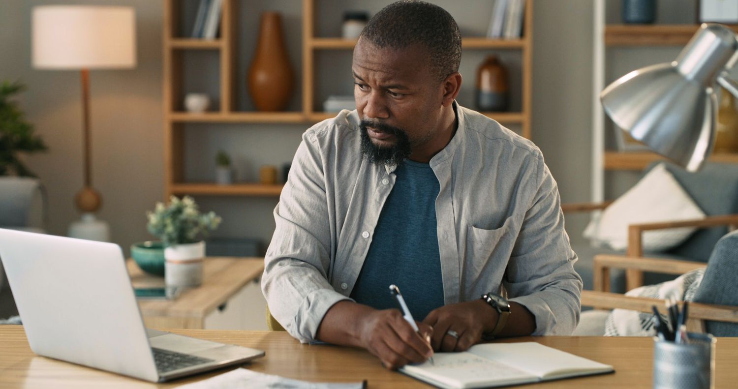 An annuity owner writes notes into a journal as they review the value of their annuity after making a scheduled systemic withdrawal.