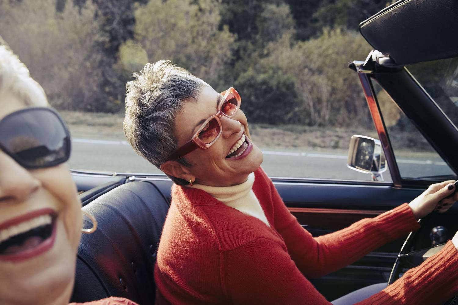 Two retirees in a convertible