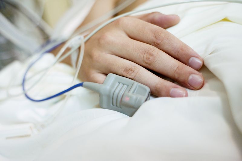 Close-up of a patient's hand in a hospital bed