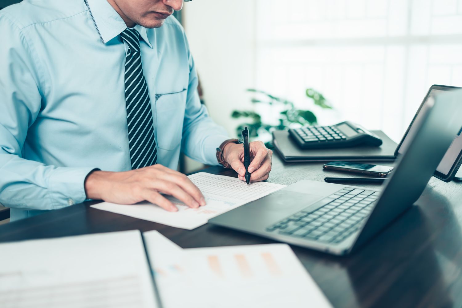 A derivative trader makes notes on a spreadsheet to keep track of portfolio's risks using zomma risk measurement.