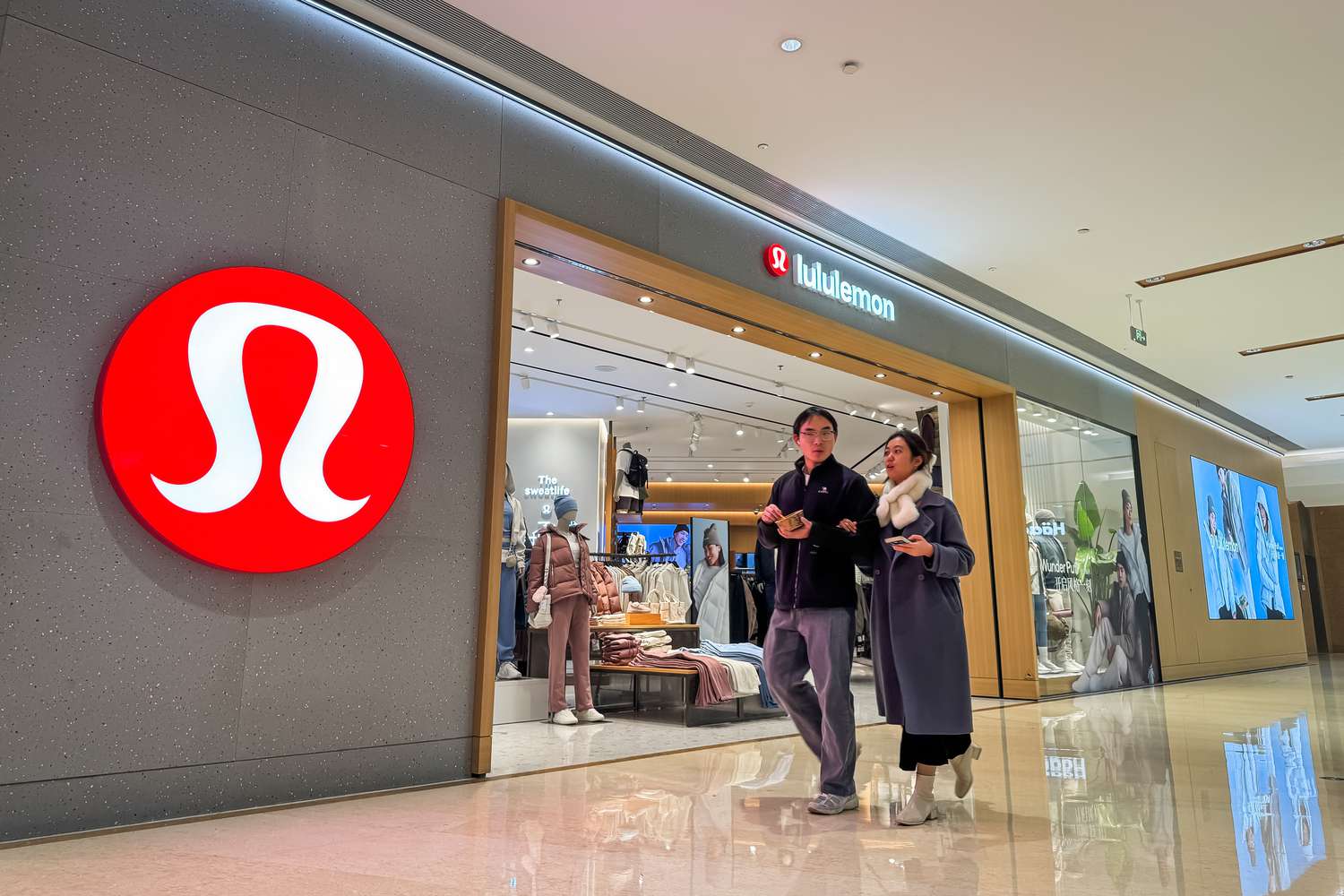 Pedestrians stroll past the Lululemon store in a modern shopping mall on December 17, 2024, in Chongqing, China