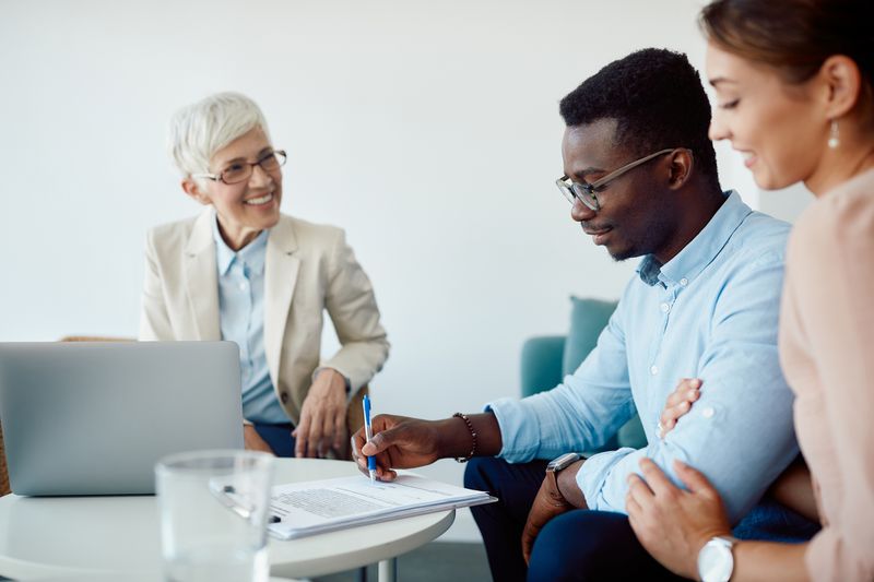 A couple signs a contract with a mortgage banker