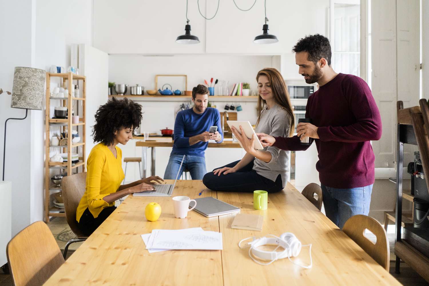 Friends hangs out in the dining room of the house that they all have a part in shared equity mortgage. 