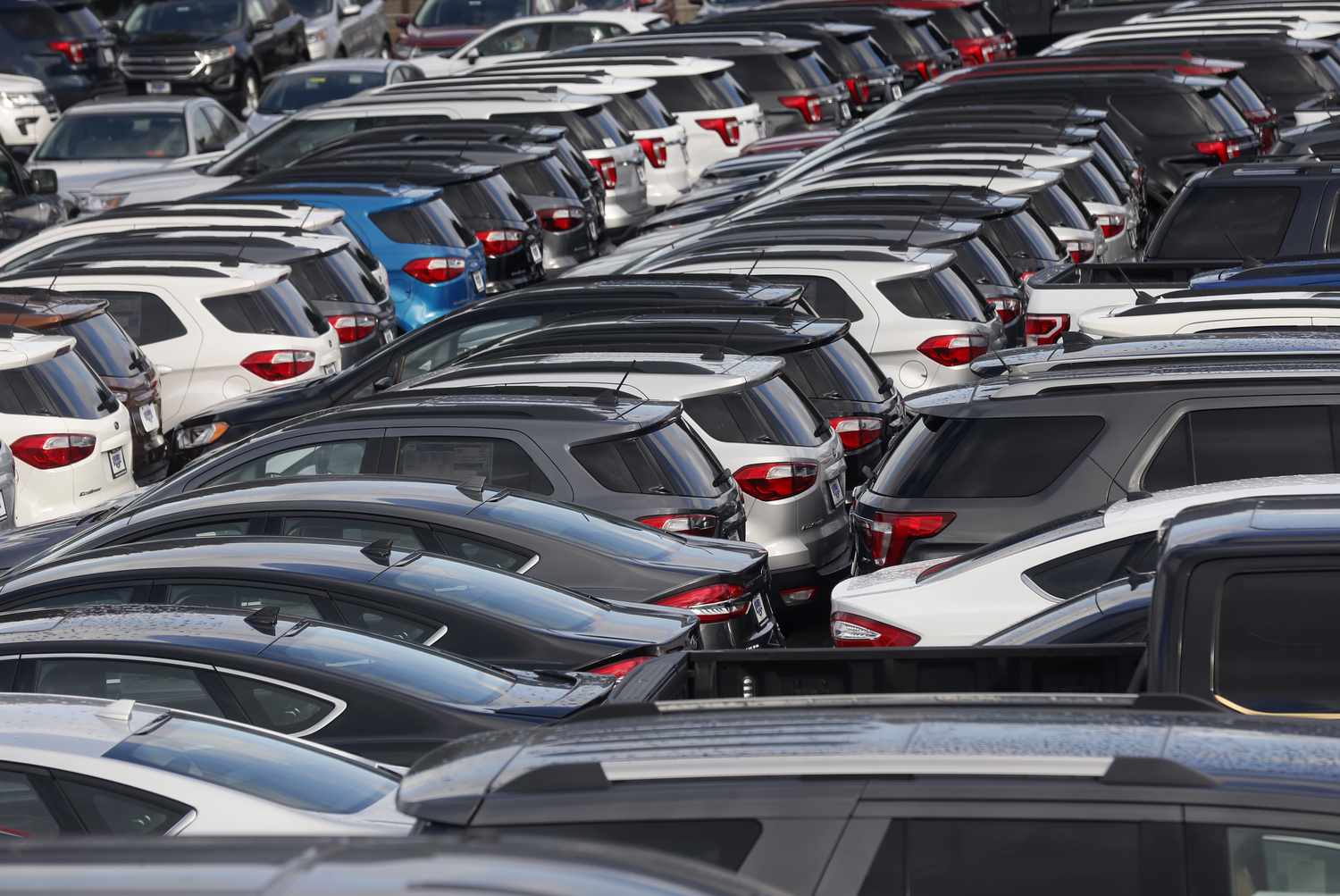 New cars and trucks are parked in the lot