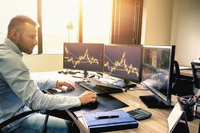 A man examining graphs at a computer