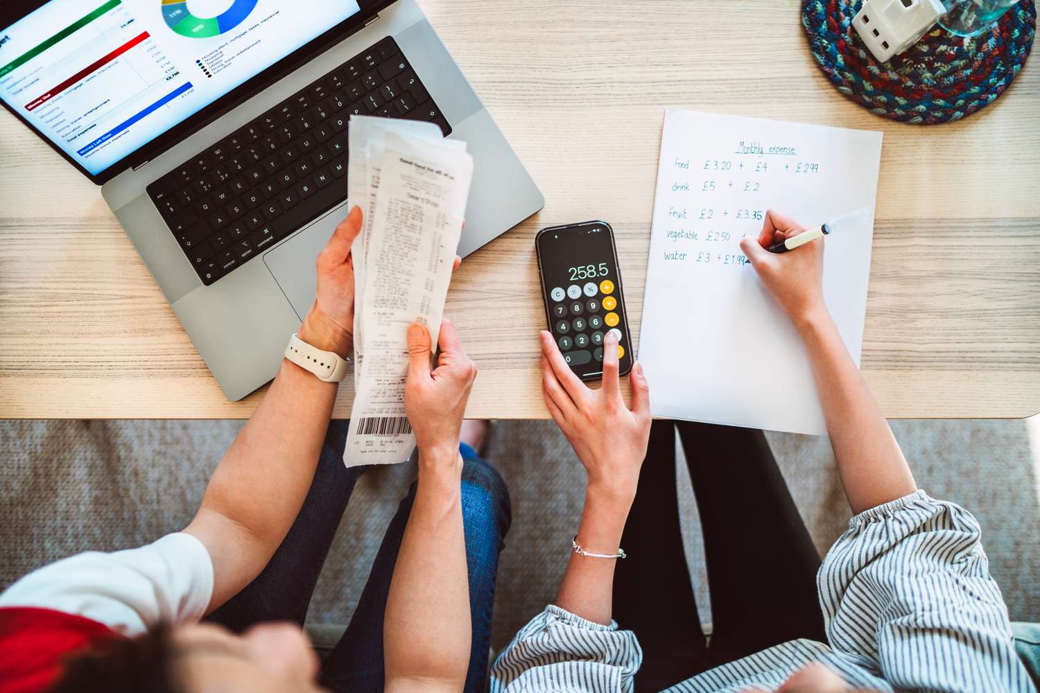 A direct above shot of a young mother and her teenage daughter working together to manage their household budget. 