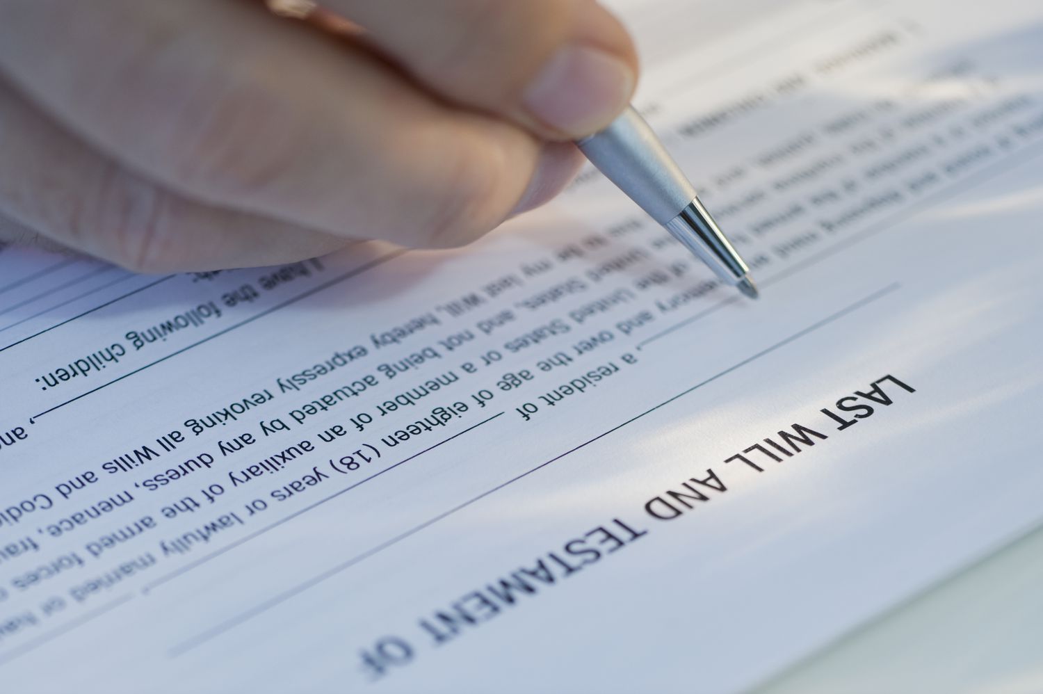Close-up of a person signing a testamentary will.