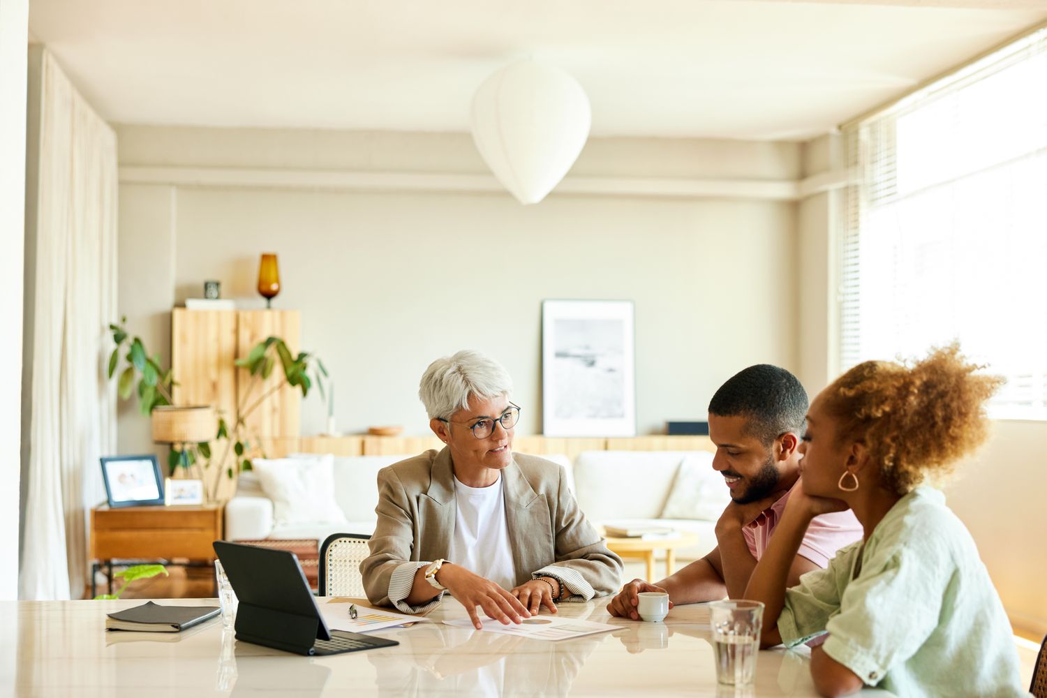 Mature female financial advisor meeting with young couple. 