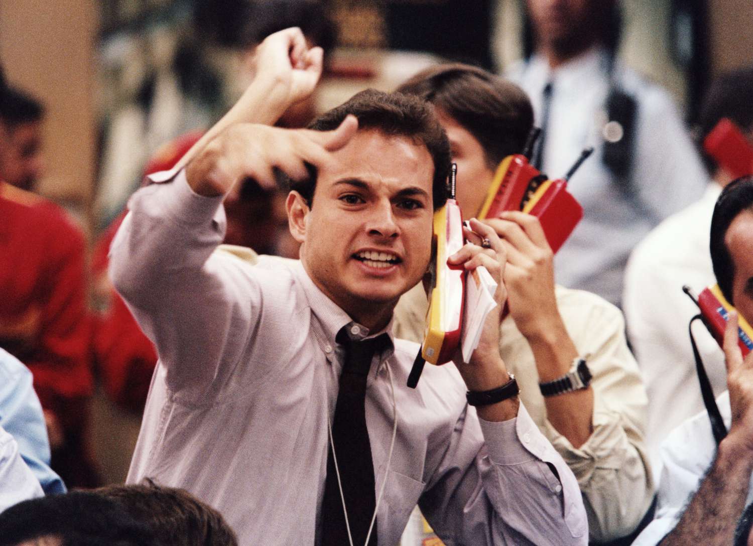 A frowning trader gesters and works frantically on the trading flow of the New York Stock Exchange as the market sells off.
