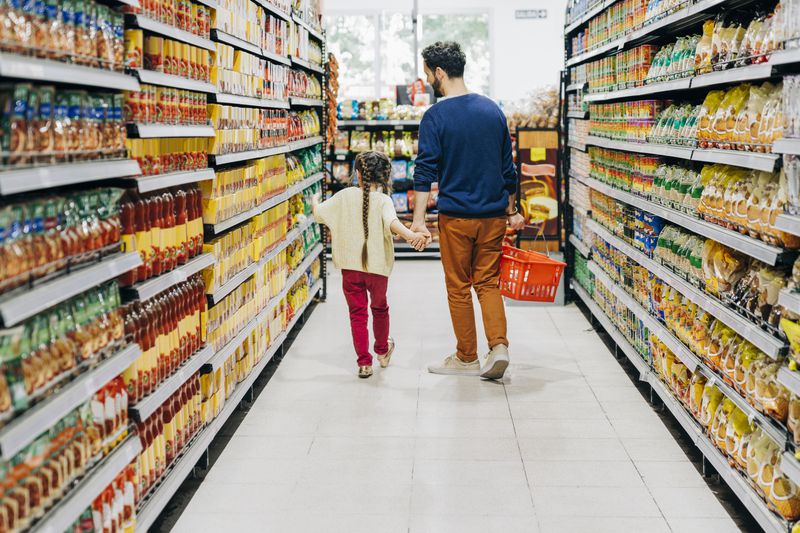 Father and daughter walking down a grocery aisle