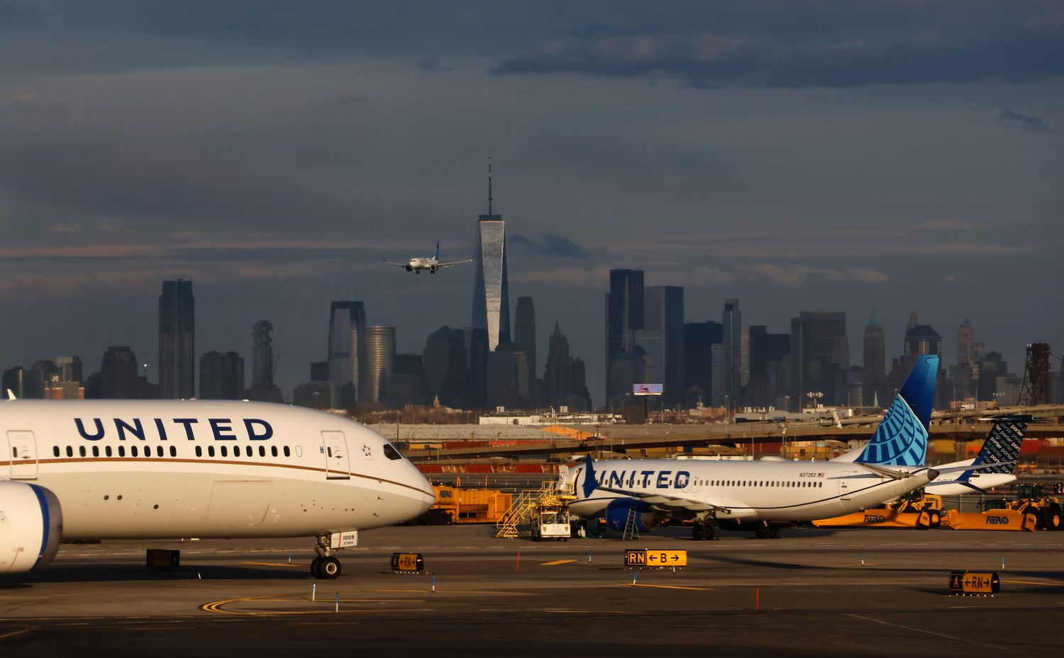 A United Airlines airplane lands at Newark Liberty International Airport in front of the skyline of lower Manhattan and One World Trade Center in New York City on March 1, 2025, in Newark, New Jersey.