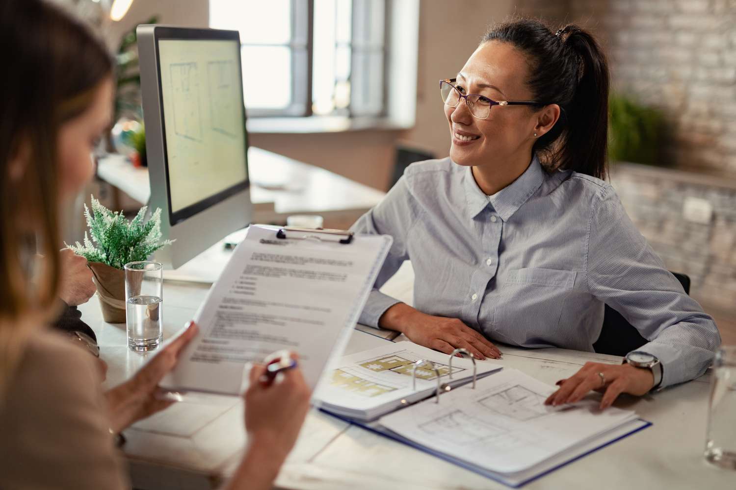 Lender talking with a borrower client during a meeting in the office.