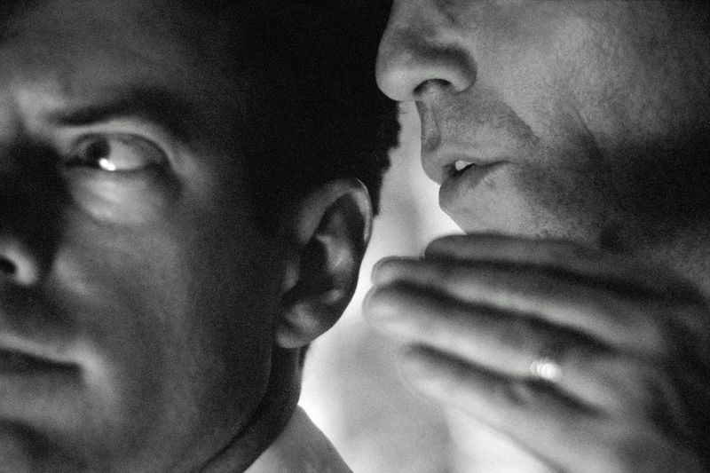 Businessman whispering to colleague