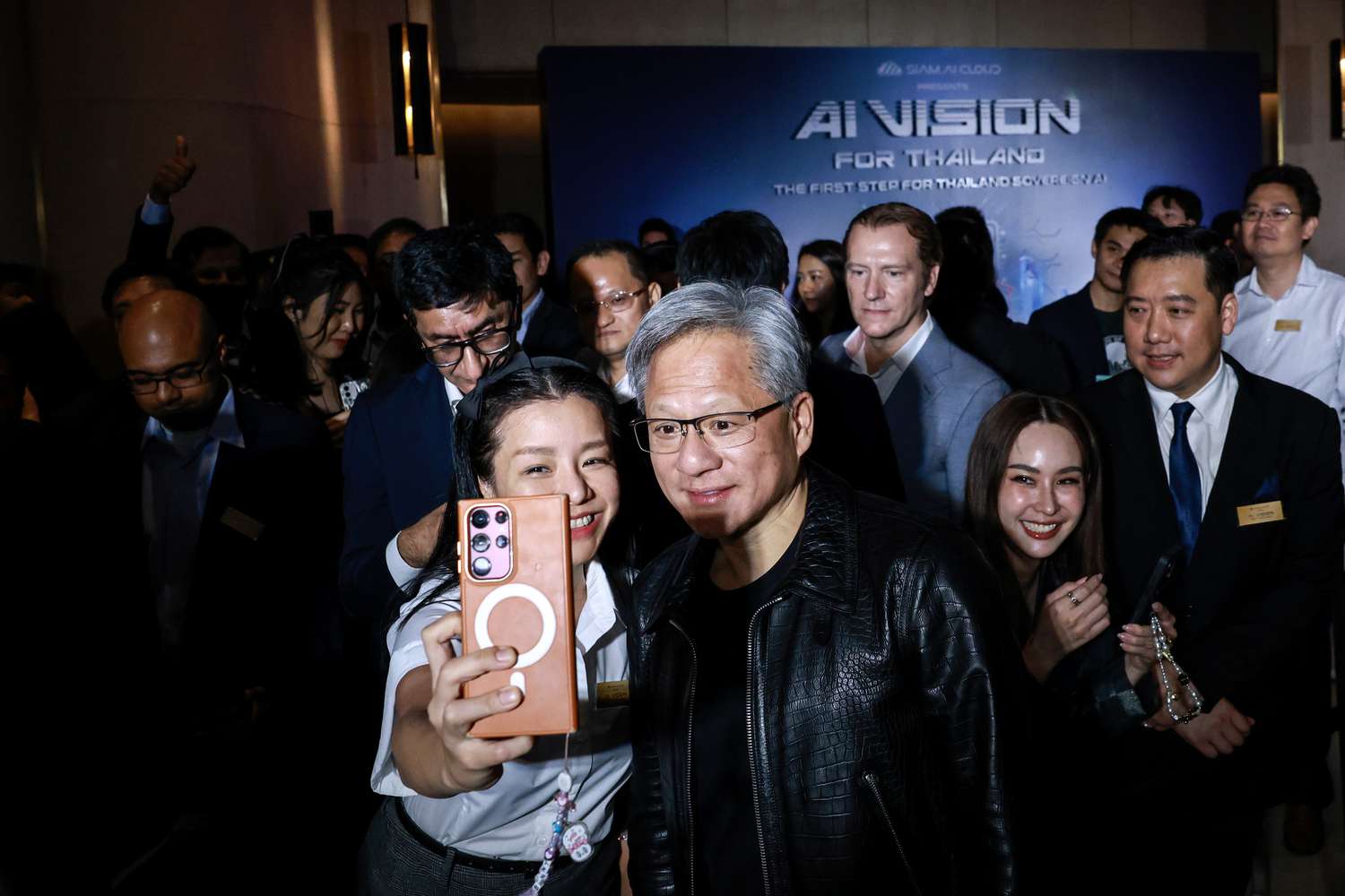 Nvidia CEO Jensen Huang, center right, poses for a selfie photograph with an attendee during the Siam AI Co. AI Vision for Thailand event in Bangkok, Thailand, on Wednesday, Dec. 4, 2024. 
