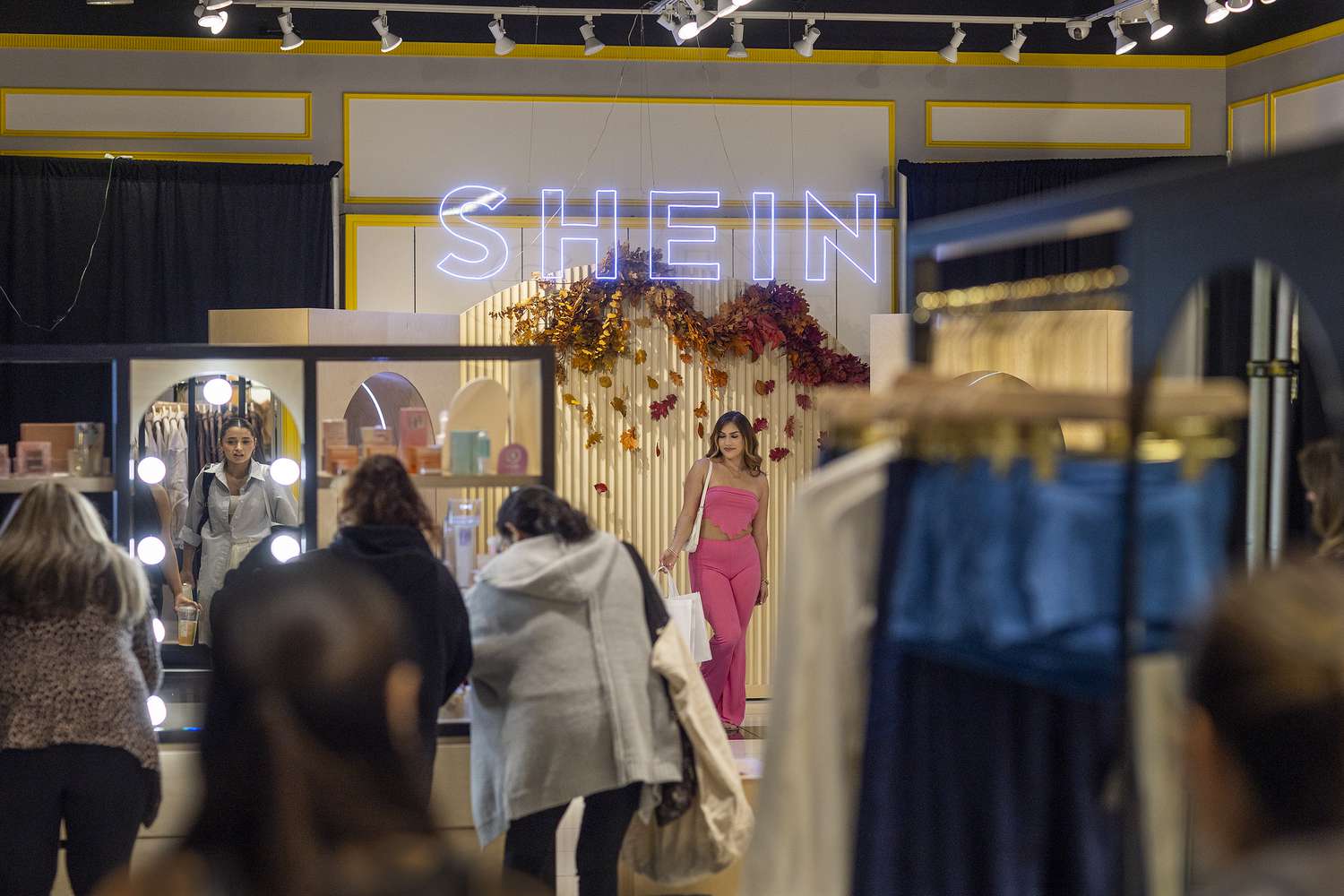 Shoppers Ashley Sanchez, center, of Fontana, poses for her friend Joscelin Flores, not pictured, who was taking photos with their bags of merchandise after being among the first group of shoppers taking the opportunity to shop on the opening day of fast fashion e-commerce giant Shein, which is hosting a brick-and-mortar pop up inside Forever 21 at the Ontario Mills Mall in Ontario Thursday, Oct. 19, 2023. 