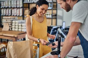 A woman makes a credit card purchase at a store.