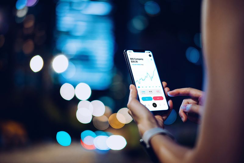 Close up of business woman checking financial data on smartphone