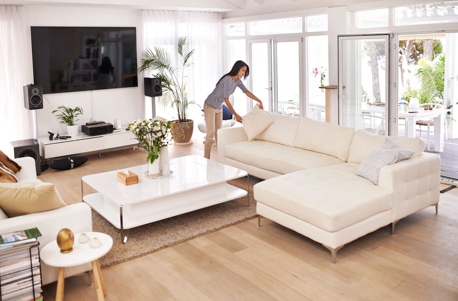 Woman tidying nicely furnished living room
