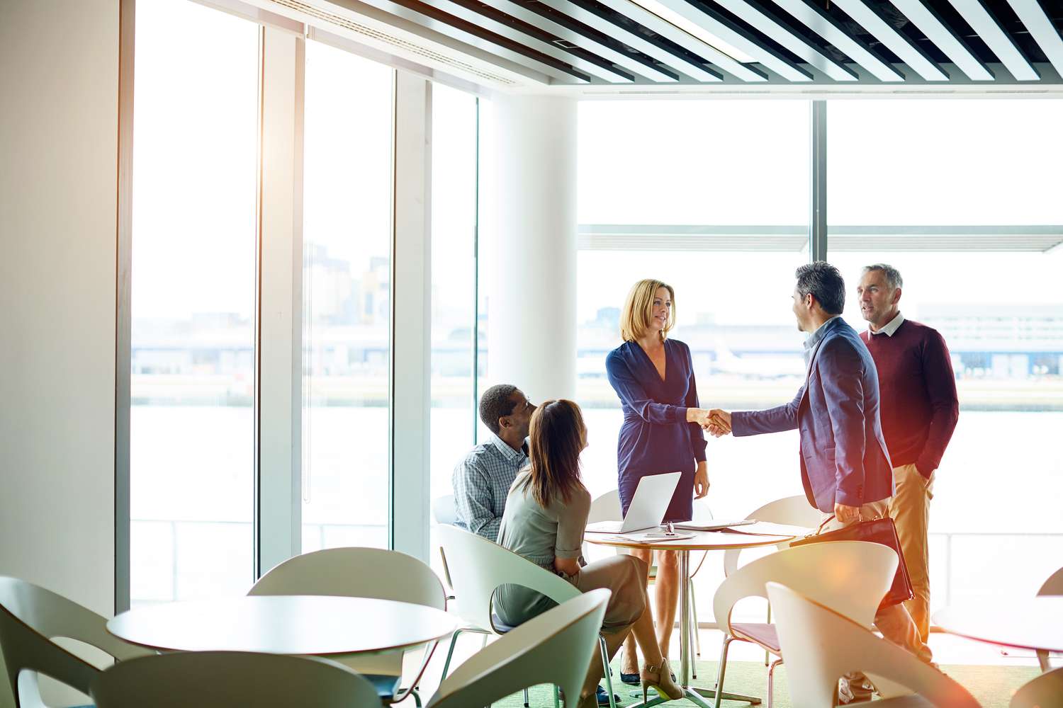 Company representatives shaking hands after agreeing to a new round of funding for the business