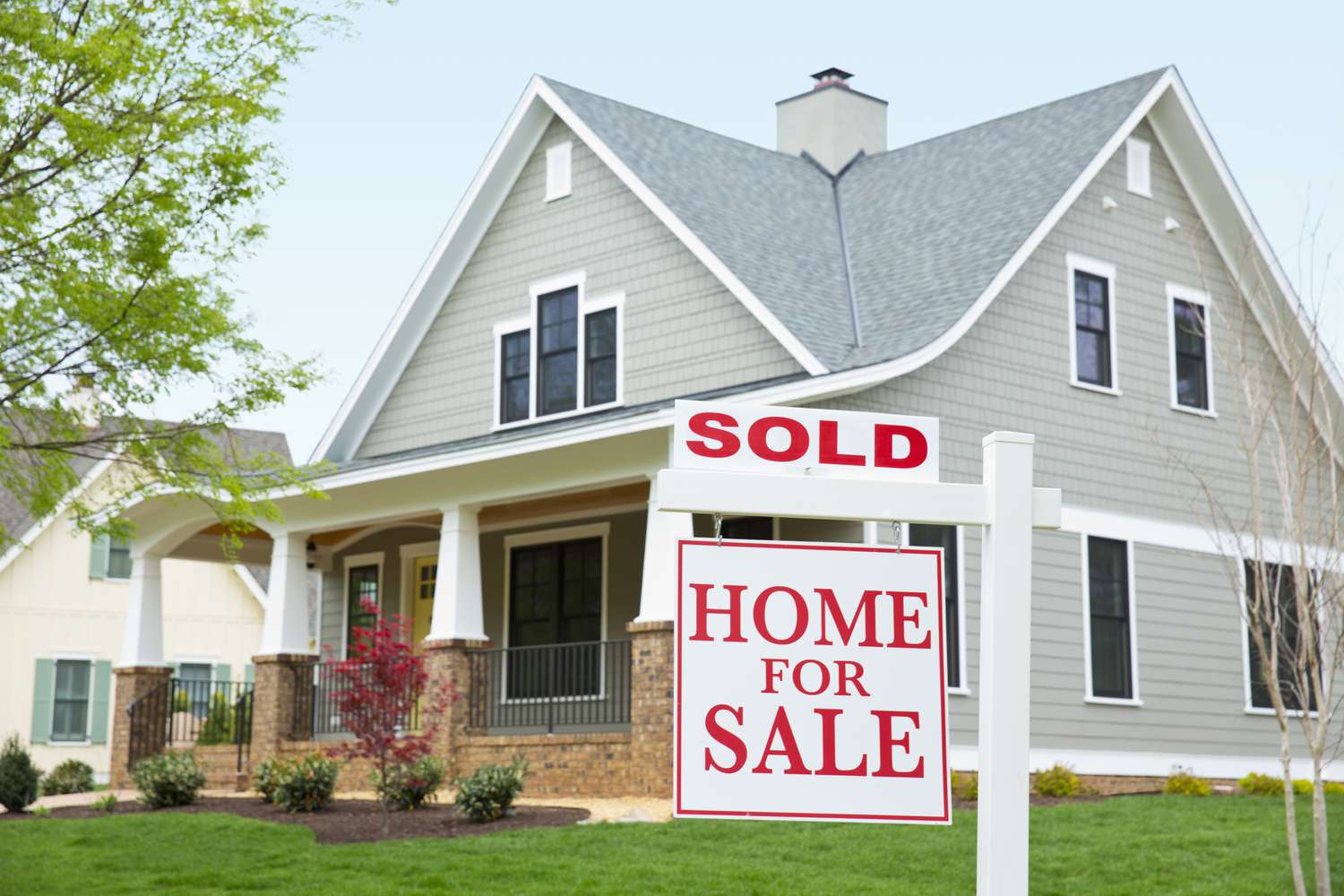 Home with a sold and home for sale sign