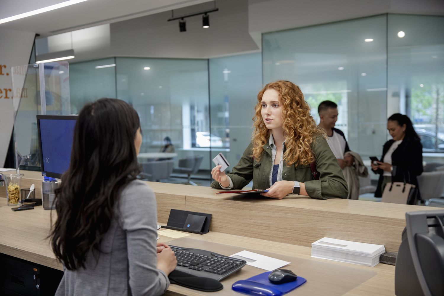 Young woman talks with bank teller