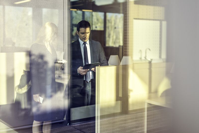 Businessman showing businesswoman something on a tablet in an office