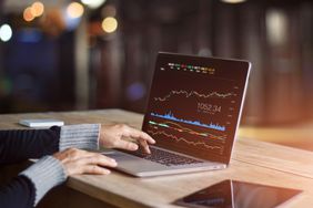 A person using a laptop for analyzing data stock market.
