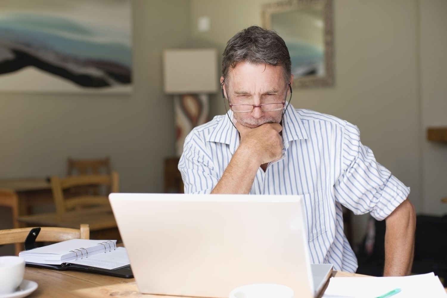 White man scrutinizing laptop screen