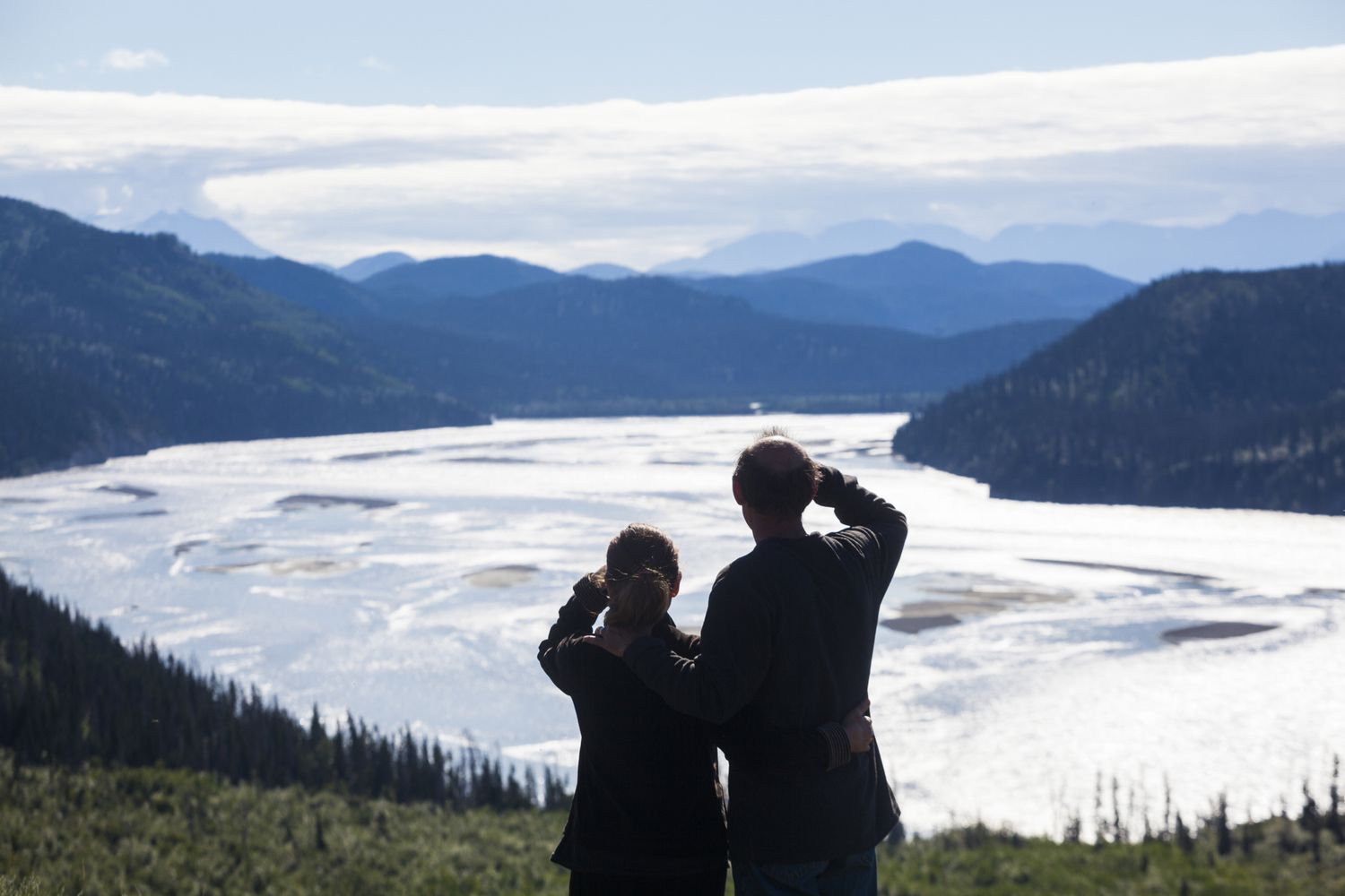 A man and woman look out over the Chitina River river valley near Chitina, Alaska.