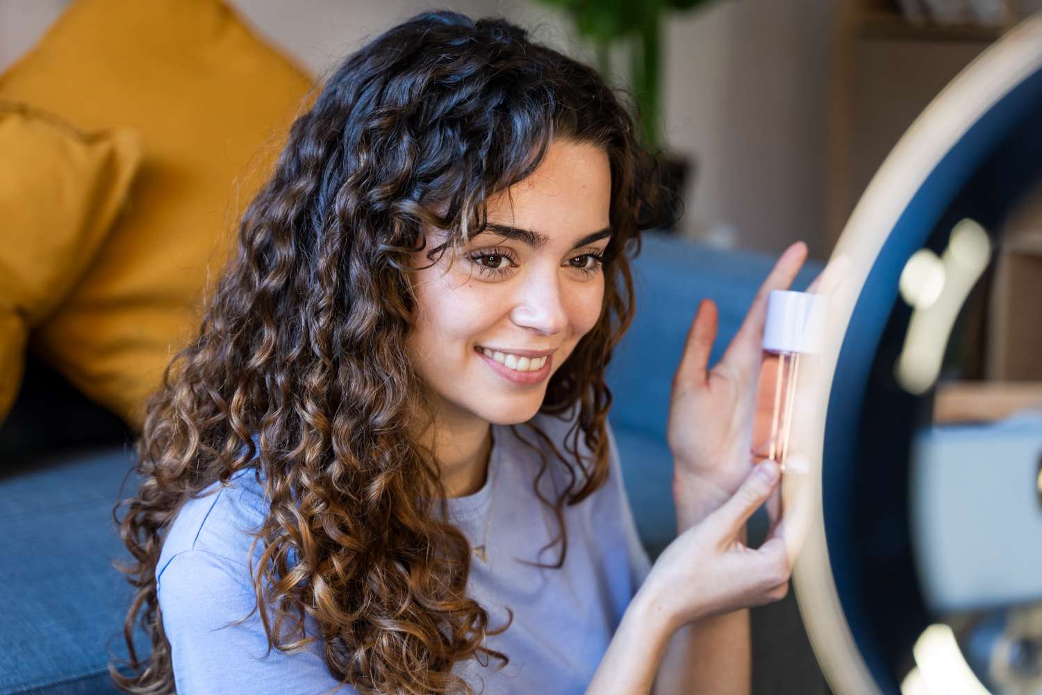Woman with curly hair reviewing cosmetics through ring light