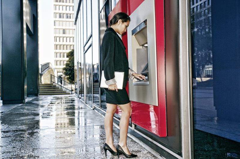 Mixed Race Businesswoman Using ATM in City