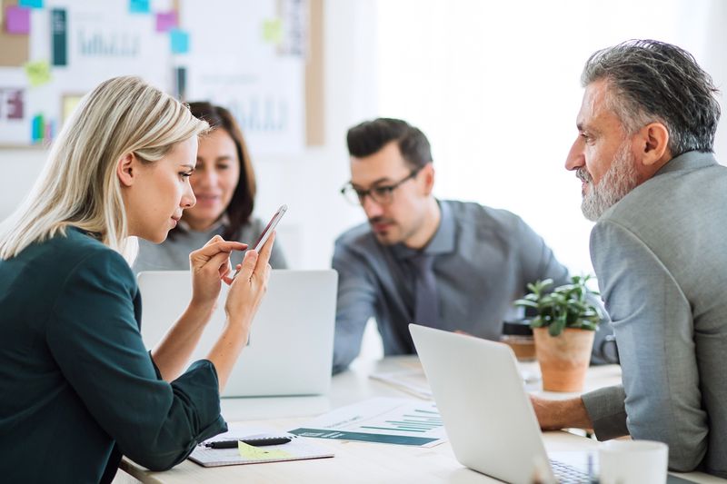 Businesspeople Sitting Around the Desk in an Office, Having Meeting