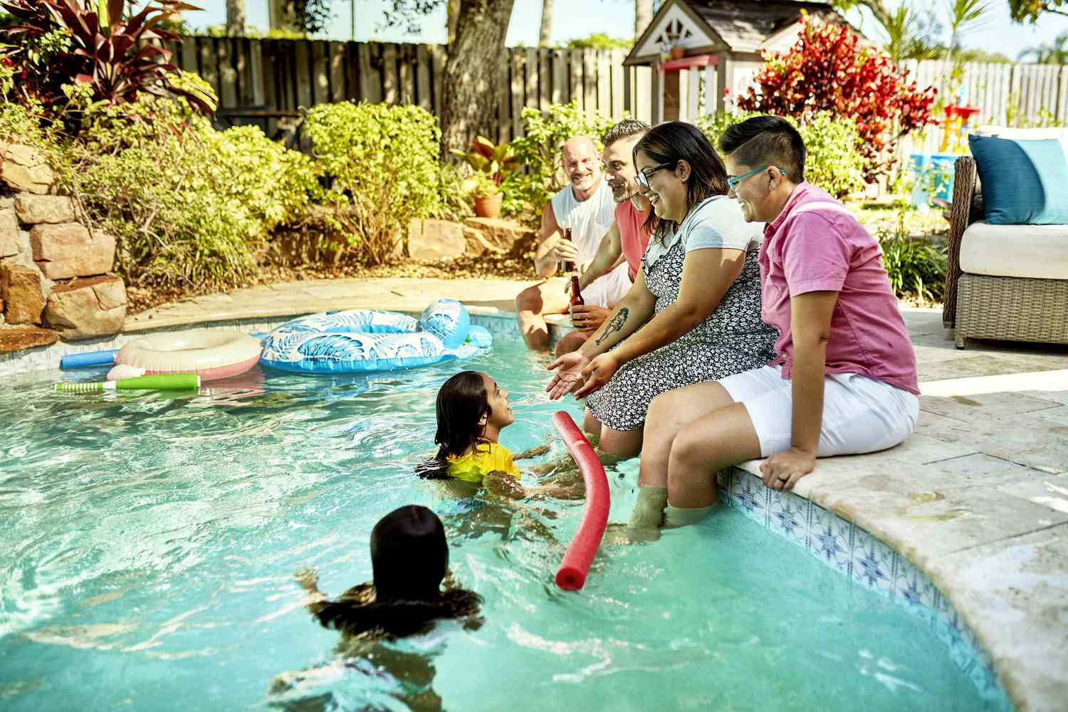 Parents and children enjoy their backyard pool