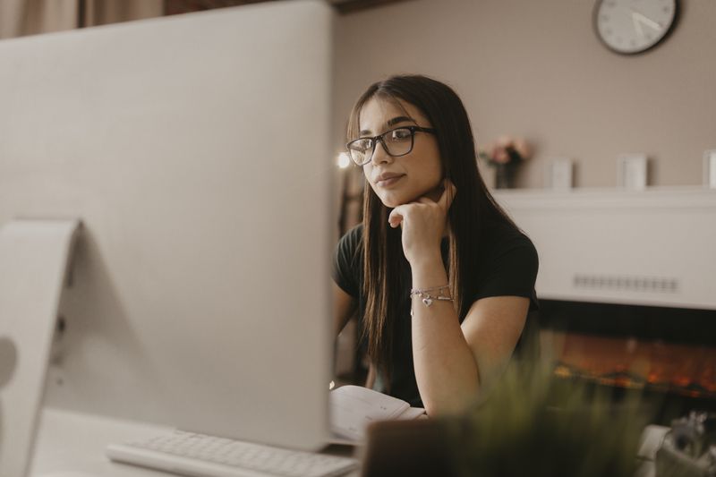 Prospective student reads on her computer about what bank accounts are worth knowing about before she goes to college
