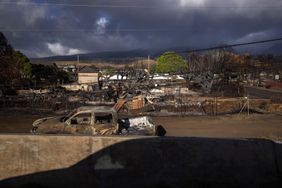 The shadow of a car near homes that burned during the 2023 wildfires in Maui, Hawaii. 