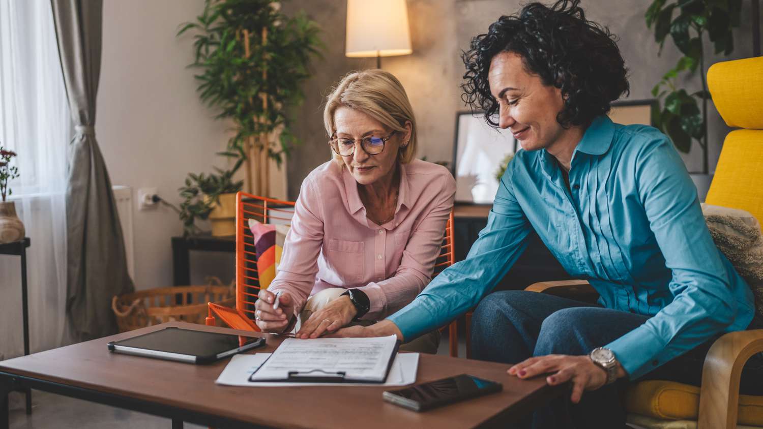 Two women looking over a document together.