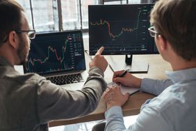 Traders monitoring market data on two screens