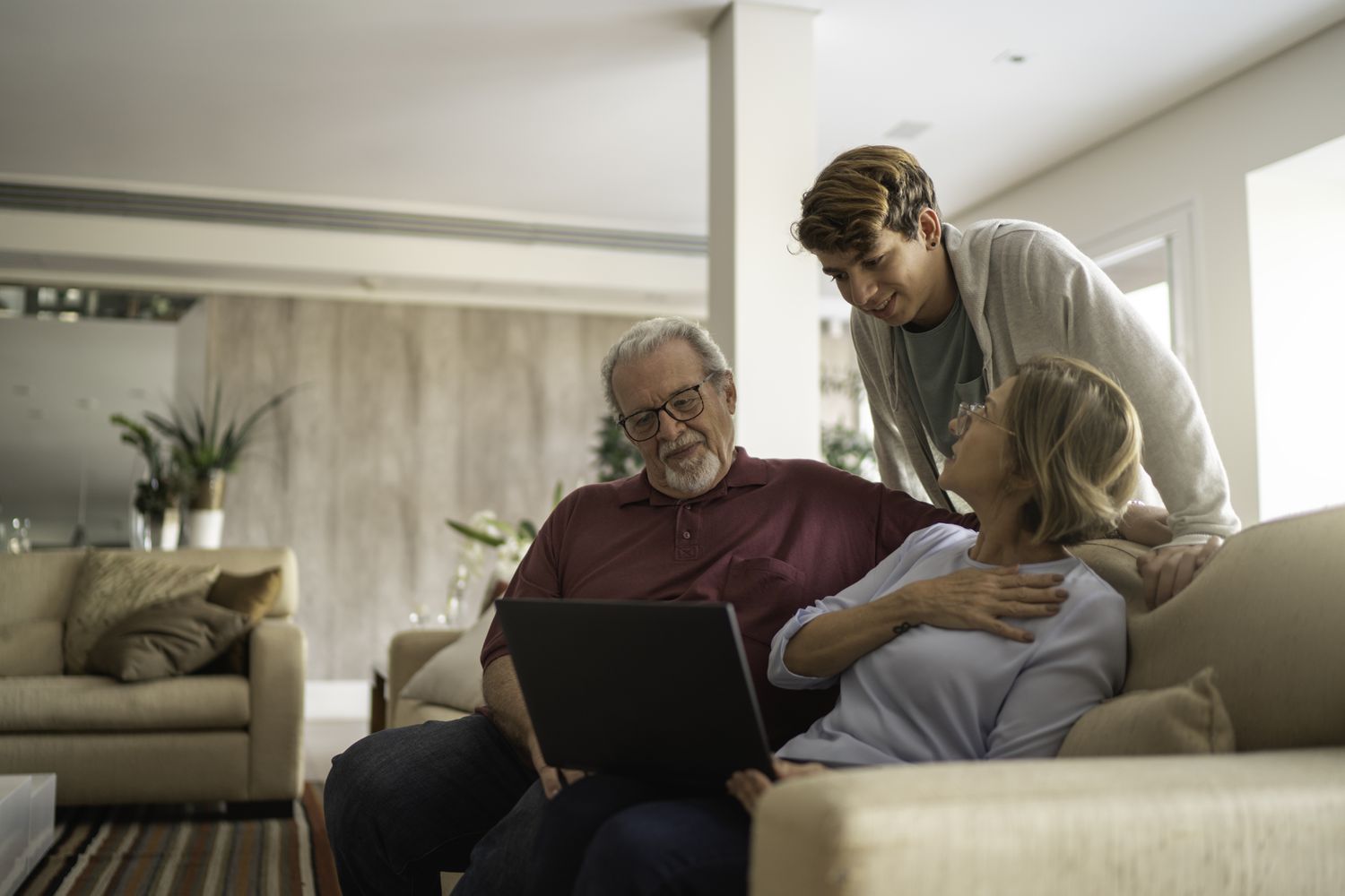 Young man looking at a laptop with older adults