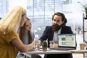 Financial advisor explaining a detail to two clients.