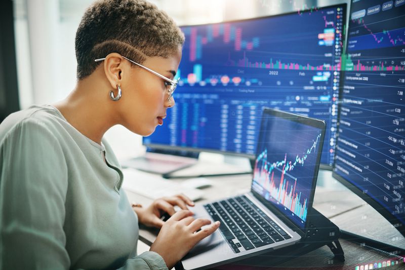 Stock trader using trading software to manage investments.