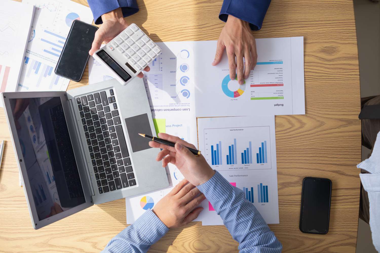 Two business accountants review printouts of quarterly company performance and discuss changing the amount of profits paid out to shareholders based on a target payout ratio.