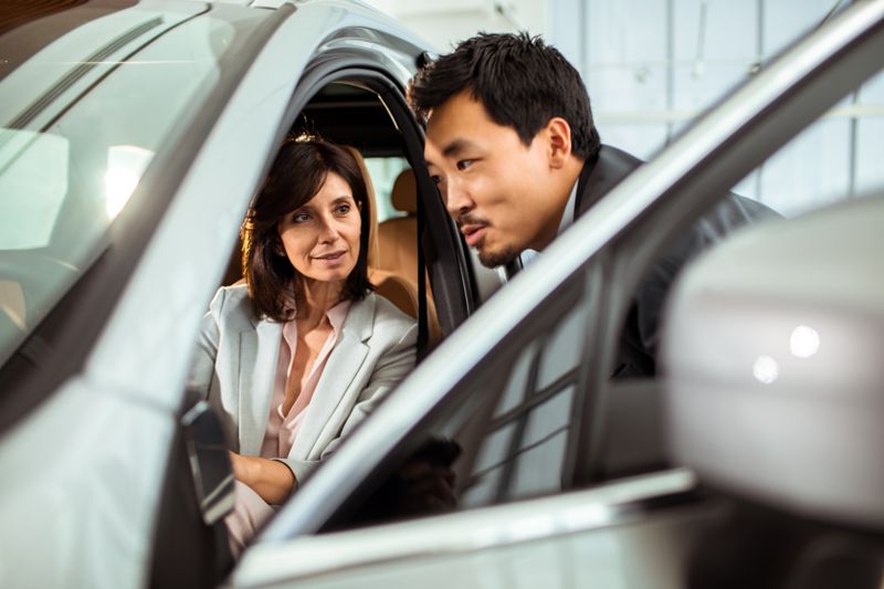 Man selling car to woman